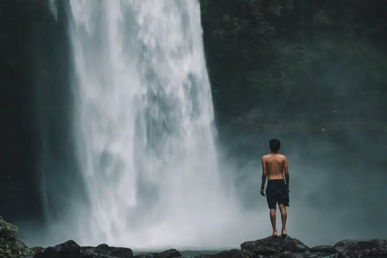 Man ready to bathe in Nungnung Waterfall, Bali