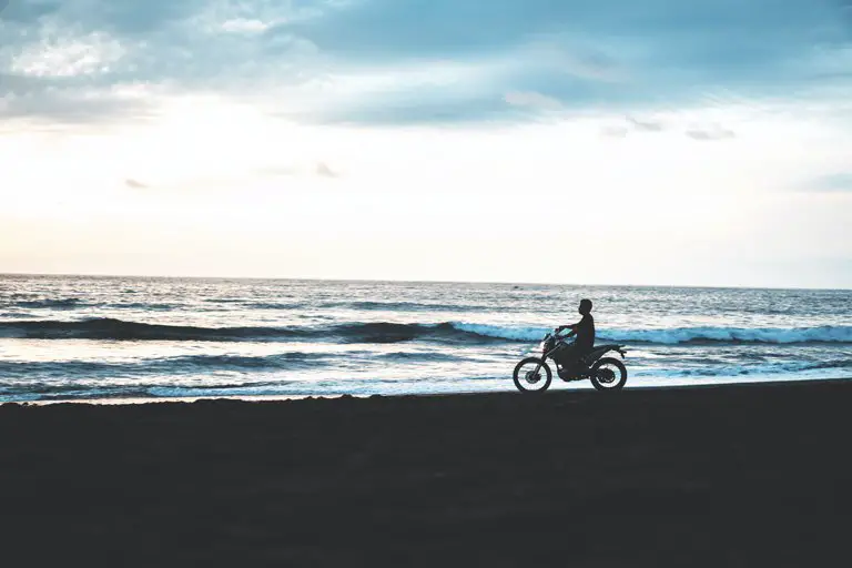Man riding his motorbike on the beach in Pigstone, Bali