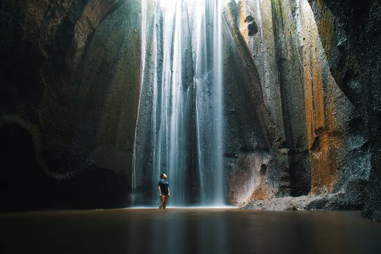 Person inside the Tukad Cempung waterfall, Bali