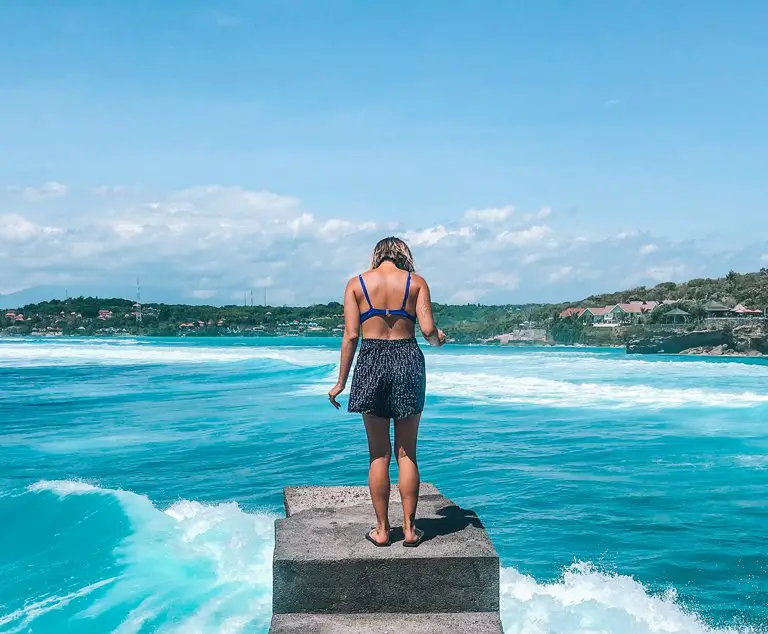 Girl looking at the waves in Nusa Ceningan, Bali